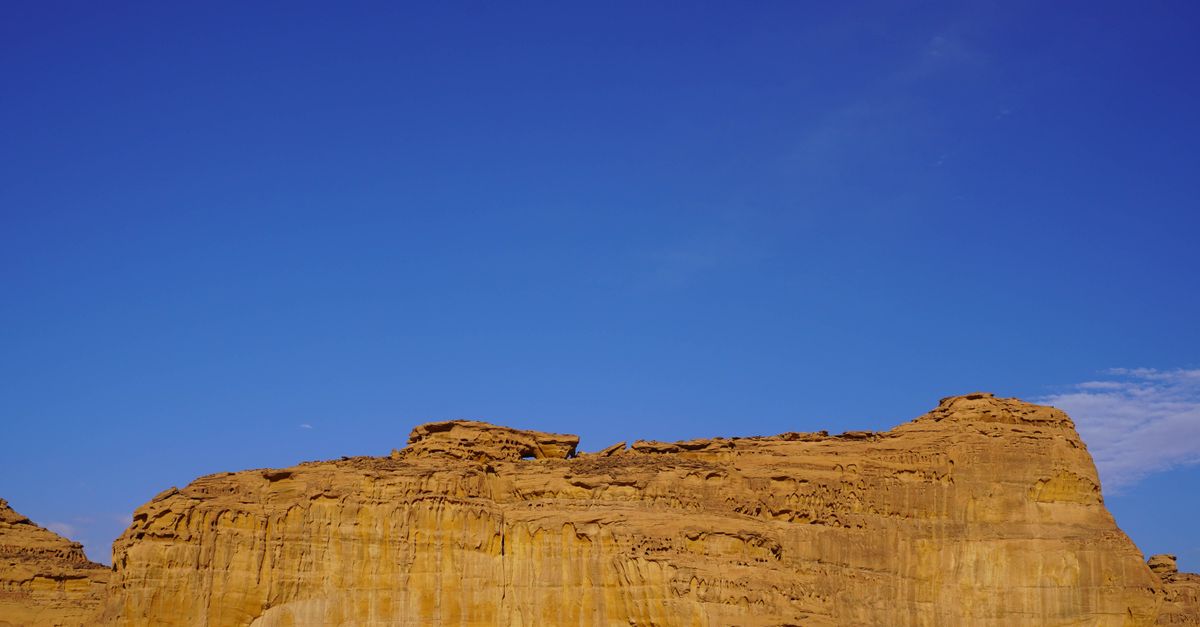Stunning desert rock formation with a clear blue sky, showcasing the beauty of natural landmarks.